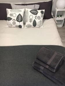 Cama con almohadas blancas y negras y manta en Apartamento Castro Celta, en Vigo