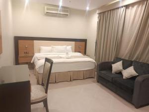 um quarto com uma cama, uma cadeira e um sofá em الناصر em Jeddah