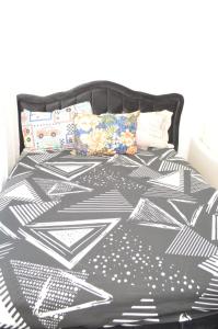 a black and white comforter on a bed at Professional Studio Appartment in Bobigny