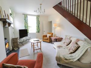 a living room with a couch and a fireplace at Prince's Cottage in Thornhill