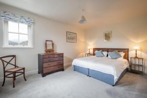 sypialnia z łóżkiem, krzesłem i oknem w obiekcie Prince's Cottage w mieście Thornhill