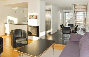 HavnebyにあるBeautiful Apartment In Rm With Kitchenのリビングルーム(ソファ、テーブル付)、キッチンが備わります。