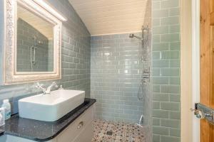 a bathroom with a sink and a shower at Relaxing Retreat - The Shepherds Hut - Hot Tub in White Waltham