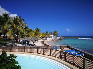 Elle offre une vue sur la plage dotée de chaises et l'océan. dans l'établissement Le Colibri des Alizés, à Saint-François