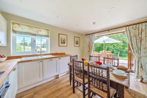 a kitchen with a sink and a table with chairs at Cosy Cottage in Dorchester