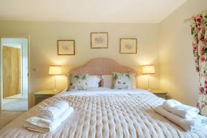 una camera da letto con un grande letto bianco con asciugamani sopra di Cosy Cottage a Dorchester