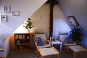 a room with chairs and a table and a book shelf at Weitblick-Loft mit Terrasse in Rostock