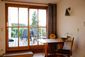 ein Esszimmer mit einem Tisch und einem großen Fenster in der Unterkunft Weitblick-Loft mit Terrasse in Rostock