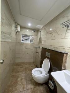 a bathroom with a white toilet and a sink at Boulevard Resorts in Kakkadampoyil