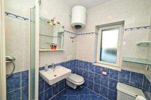 a blue and white bathroom with a sink and a toilet at Apartments Bozikovic in Podstrana +49 photos