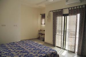 une chambre avec un lit et deux grandes fenêtres dans l'établissement Appartement entier proche de la plage Yoff BCEAO A2, à Dakar