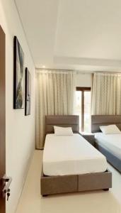 um quarto com duas camas num quarto em Hawana VIP Private Apartment em Wādī Khasbar