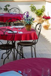 una mesa roja con sillas y flores. en Al Cantuccio, en Castelluzzo