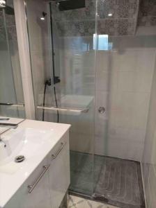 een badkamer met een douche en een witte wastafel bij Grande maison traversante. in Saint-Gilles
