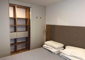 Habitación con cama con 2 almohadas en Grand mobile-home 45M2 au calme et au bord de mer en Saint-Brevin-les-Pins