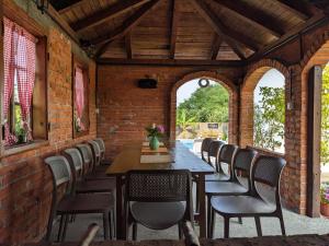 een eetkamer in de openlucht met een tafel en stoelen bij Wisteria Lodge in Derventa