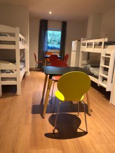 Zimmer mit einem Tisch, Stühlen und Etagenbetten in der Unterkunft Estelada Boarding Houses in München
