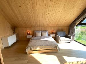 a bedroom with a bed and a large window at Love Wysove in Wysowa-Zdrój