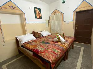 Un dormitorio con una cama con un juguete. en Hotel Sandstone Villa,, en Jaisalmer