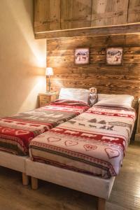 2 camas num quarto com paredes de madeira em Zenith Appartements VTI em Val Thorens