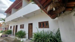 伊比科阿拉的住宿－Residencial Maria de Lourdes，一座白色的建筑,有门和一些植物