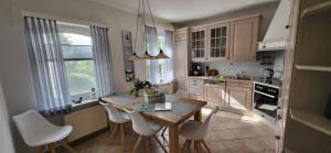 a kitchen with a wooden table and white chairs at Ferienhaus Gesine 25193 in Bunde