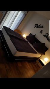 een bed met zwarte kussens op de vloer in een kamer bij Ferienhaus Gesine 25193 in Bunde