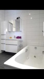 een witte keuken met een bad en een wastafel bij Ferienhaus Gesine 25193 in Bunde