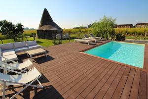 une terrasse en bois avec une piscine et des chaises longues dans l'établissement Le Maginot Relais, 
