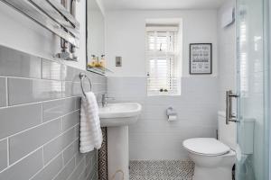 a white bathroom with a sink and a toilet at Beta House by Night Stay: Contractors Sleeps 9 in Birmingham