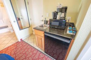 a small kitchen with a sink and a microwave at Low Floor,Direct Oceanfront,Heated Pool,Boardwalk! in Myrtle Beach