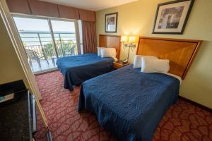 a hotel room with two beds and a window at Low Floor,Direct Oceanfront,Heated Pool,Boardwalk! in Myrtle Beach