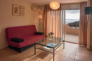 sala de estar con sofá rojo y mesa de cristal en Camping Naturista El Portús - Nudist FKK, en Cartagena