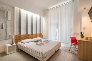 ローマにあるSt Peter Roomsのベッドルーム1室(大型ベッド1台、赤い椅子付)