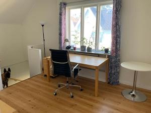ein Büro mit einem Schreibtisch, einem Stuhl und einem Fenster in der Unterkunft Good cheap apartment in a central location in Borås