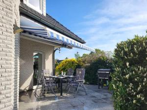 a patio with a table and chairs and a grill at Ferienhaus Gesine 25193 in Bunde