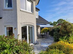 Cette maison dispose d'une terrasse avec une table et des chaises. dans l'établissement Ferienhaus Gesine 25193, à Bunde