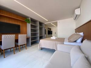 Un dormitorio con una cama, un televisor y un sofá. en Bela Hospedagem - #Unity Flats Cabo Branco, en João Pessoa