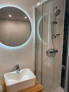 a bathroom with a sink and a shower with a mirror at Domek pod gwiazdami z jacuzzi in Brzozowa