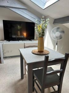 a table with a vase of flowers on top of it at Studio proche Gare in Bourg-en-Bresse