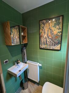 a bathroom with a sink and green tiles at Pod Lubogoszczem in Mszana Dolna