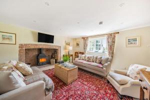 a living room with two couches and a fireplace at Crumpet Cottage in Dorchester