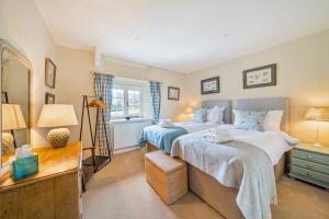 a bedroom with two beds and a mirror at Crumpet Cottage in Dorchester