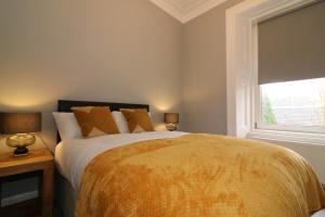 a bedroom with a large bed and a window at Signature - Linden House Flat 3 in Airdrie