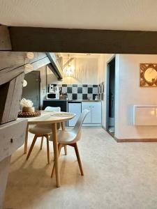 a kitchen with a table and chairs in a room at Studio Calme et Cosy -Gare- in Bourg-en-Bresse