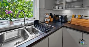 a kitchen with a sink and a laptop on the counter at Riverside - 2BR & 1BR - Flat Walk to Centre with open Parking in Cambridge