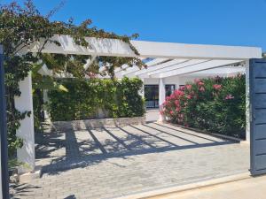 a white pergola with flowers and plants at Moraira B5 in Moraira