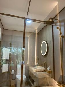uma casa de banho com um chuveiro, um WC e um espelho. em Zen garden apartment. em Vera
