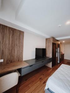een slaapkamer met een bed en een flatscreen-tv bij Beststay @Mataramcity yudhistira tower in Kejayan