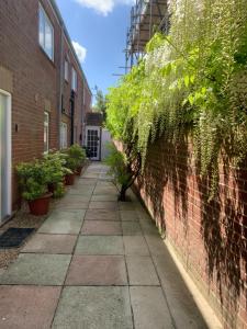 a brick alley with plants on the side of a building at The Coach Apartment in Sandwich